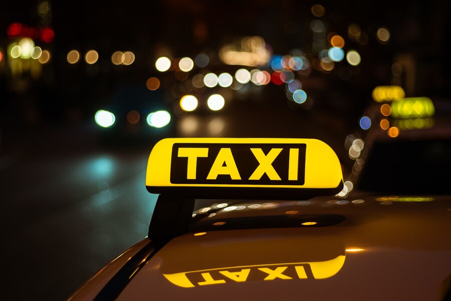 yellow-black-sign-taxi-placed-top-car-night_181624-10624